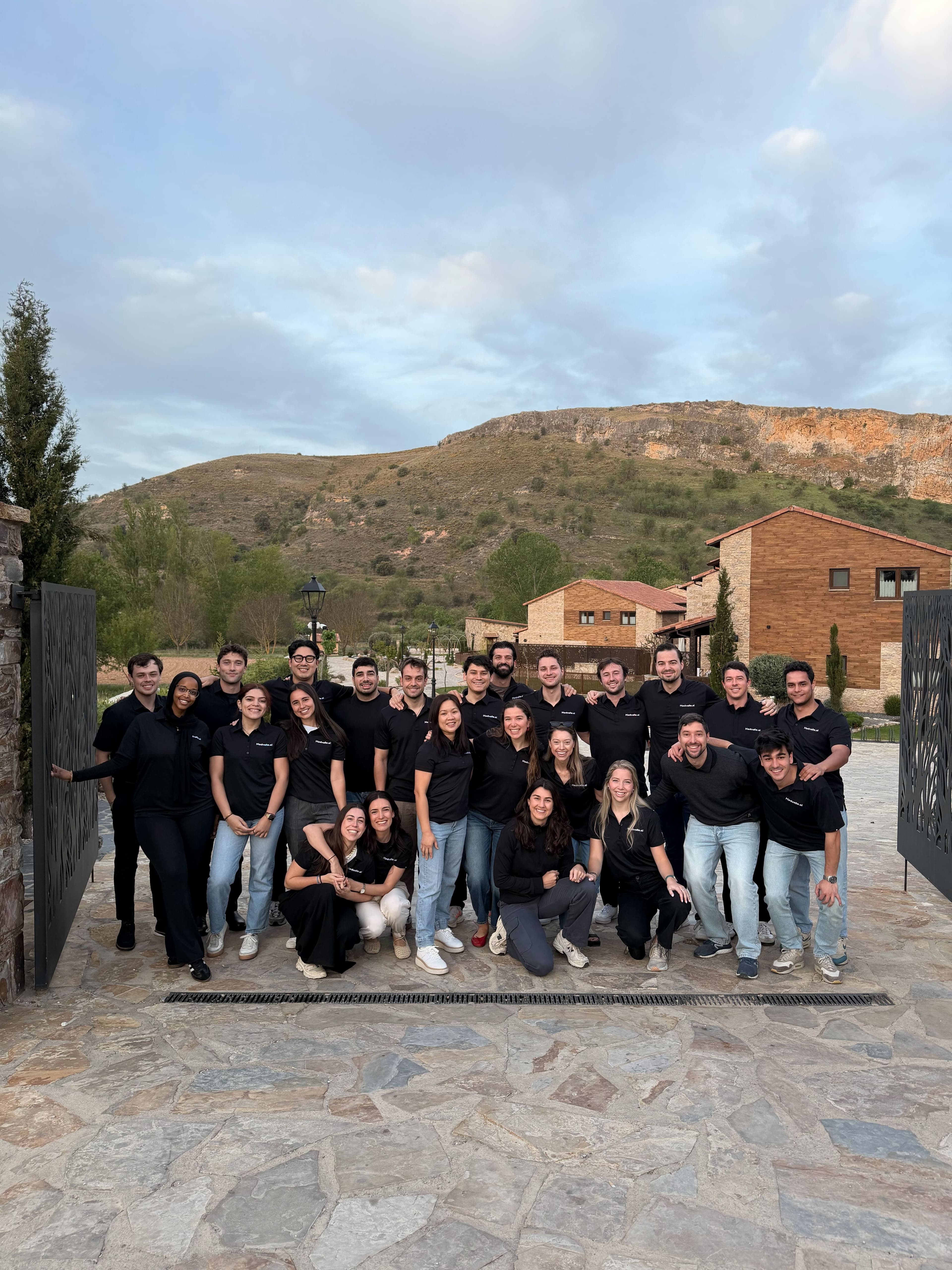 The Medvelle team, twenty-five people in matching shirts, outdoors at a company offsite
